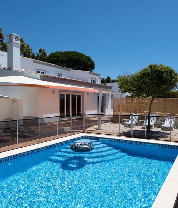 Exterior of luxury villa with garden and fenced swimming pool